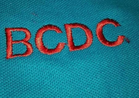 The BCDC name embroidered on a school uniform