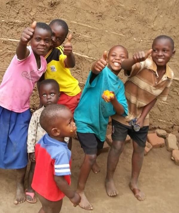 Children from the village giving a thumbs up