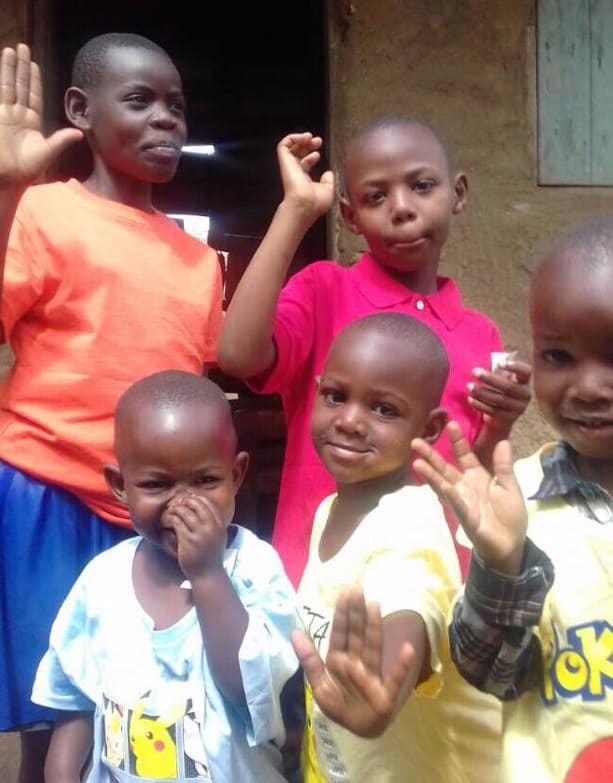 Children at the centre waving at the camera